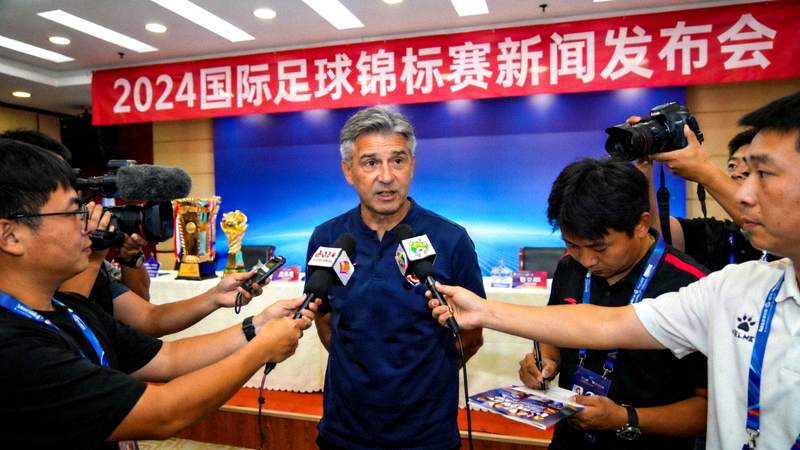 体育新闻发布现场，媒体记者正在进行赛事报道